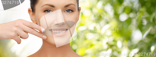 Image of face and hand of smiling woman over green tarure