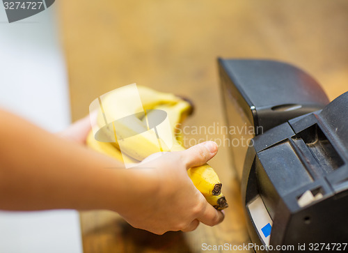 Image of close up of hands buying bananas at checkout