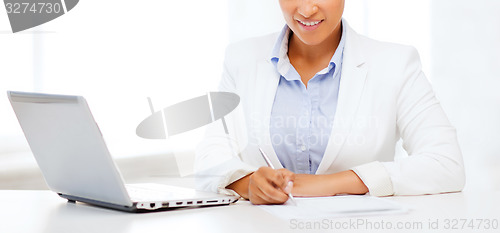 Image of african businesswoman writing something