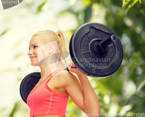 Image of smiling sporty woman exercising with barbell