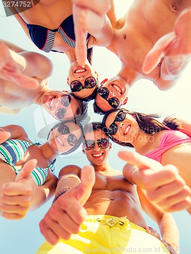 Image of smiling friends showing thumbs up in circle