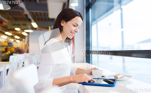 Image of smiling woman with tablet pc and coffee at cafe