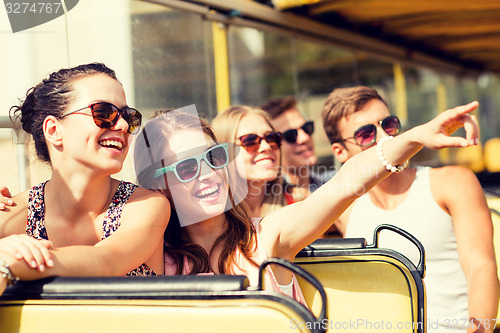 Image of group of smiling friends traveling by tour bus