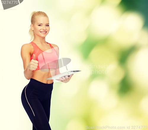 Image of smiling sporty woman with tablet pc computer