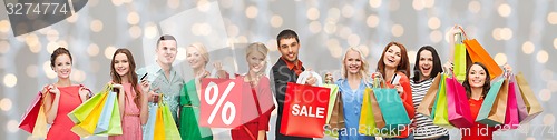 Image of happy people with sale sign on shopping bags