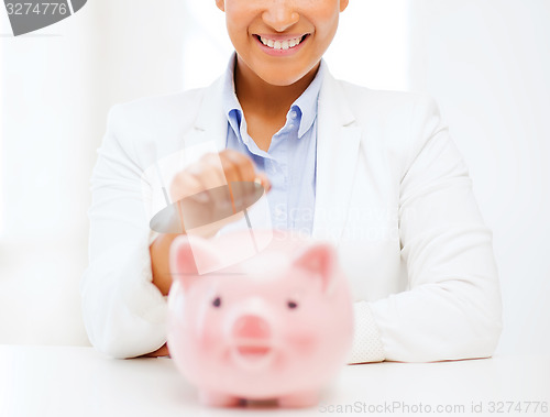 Image of woman with piggy bank and coin