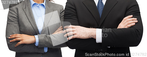 Image of businesswoman and businessman with crossed arms