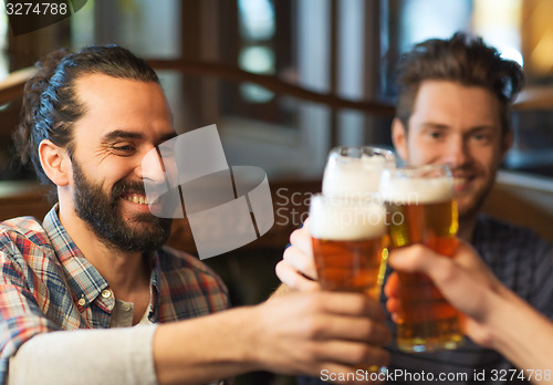 Image of happy male friends drinking beer at bar or pub