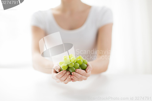 Image of close up of woman hands holding green grape bunch