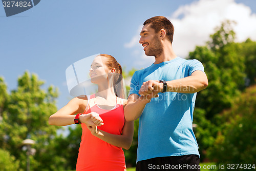 Image of smiling people with heart rate watches outdoors