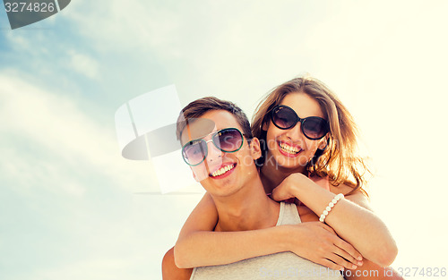 Image of smiling couple having fun over sky background