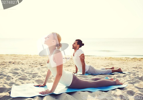 Image of couple making yoga exercises outdoors