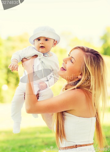 Image of happy mother with little baby sitting on blanket