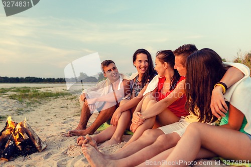Image of smiling friends in sunglasses on summer beach