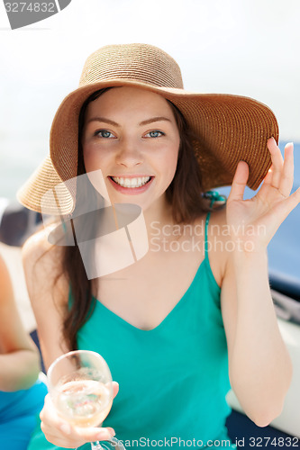 Image of smiling girl in hat with champagne glass