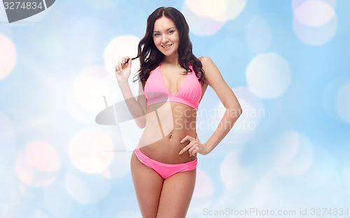 Image of happy young woman in pink bikini swimsuit