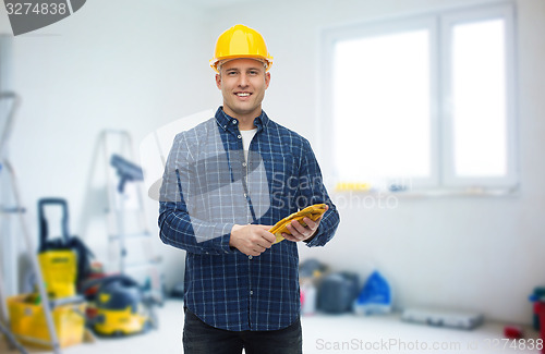 Image of smiling man in helmet with gloves over room