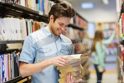 Image of happy student or man with book in library