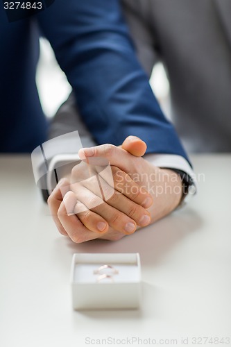 Image of close up of male gay couple and wedding rings