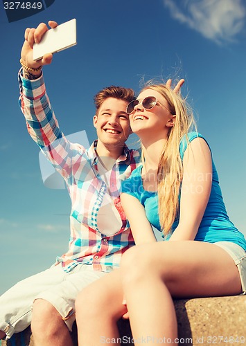 Image of smiling couple having fun outdoors
