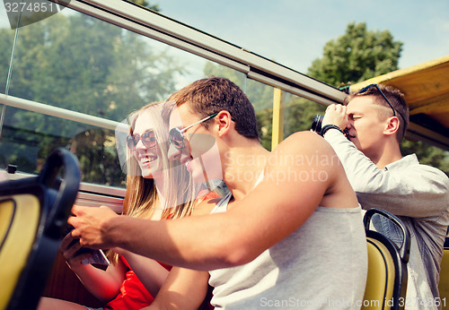 Image of smiling couple with book traveling by tour bus