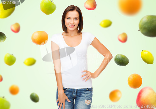 Image of happy woman in blank white t-shirt over fruits
