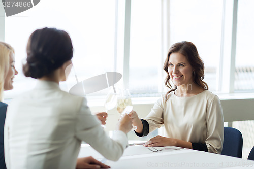 Image of happy women drinking champagne at restaurant