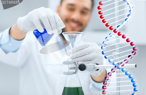 Image of close up of scientist with test tubes and funnel