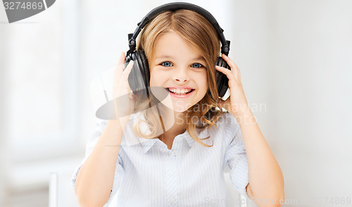 Image of little girl with headphones at home