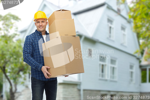 Image of smiling man in helmet with cardboard boxes