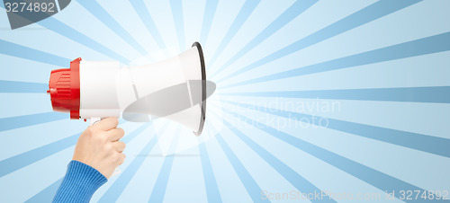 Image of woman hand holding megaphone over blue burst rays