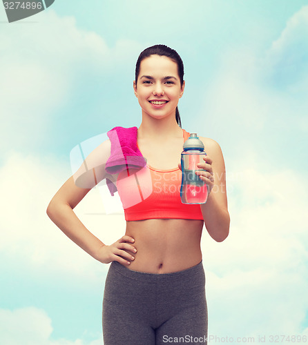 Image of sporty woman with towel and water bottle