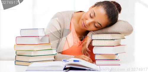 Image of tired student with books and notes