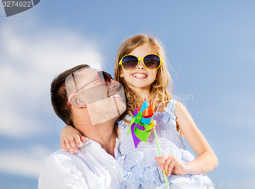 Image of happy father and child in sunglasses over blue sky