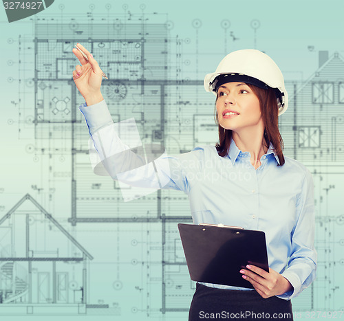 Image of smiling businesswoman in helmet with clipboard