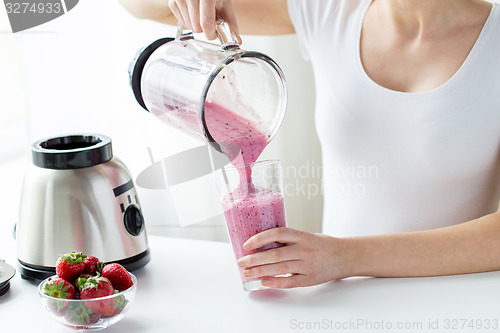 Image of close up of woman with blender pouring milk shake