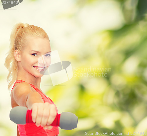 Image of smiling beautiful sporty woman with dumbbell