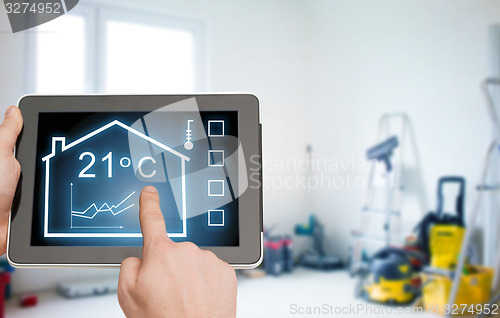 Image of close up of tablet pc in hands setting temperature