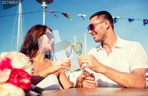 Image of smiling couple drinking champagne at cafe