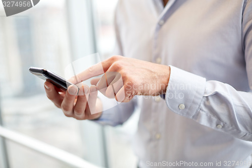 Image of close up of man hands with smartphone at office