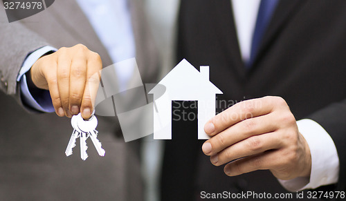 Image of businessman and businesswoman holding white house