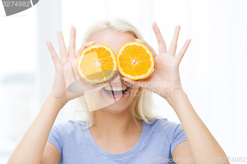 Image of happy woman having fun covering eyes with orange