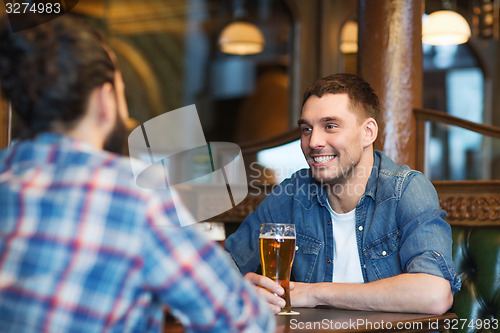 Image of happy male friends drinking beer at bar or pub