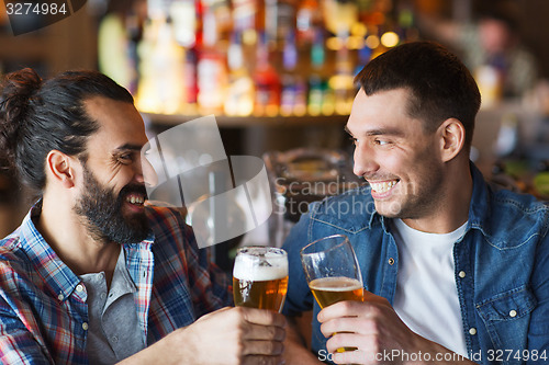 Image of happy male friends drinking beer at bar or pub