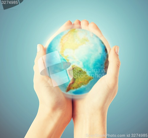 Image of close up of human hands with earth globe