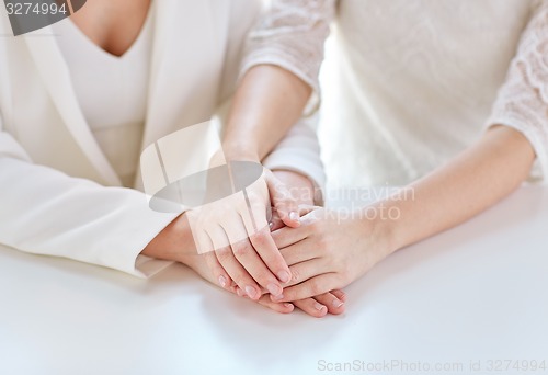 Image of close up of happy married lesbian couple hands