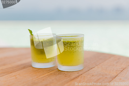 Image of glasses of fresh juice or cocktail on beach