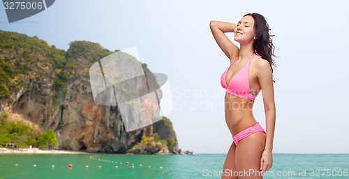 Image of happy young woman in pink bikini swimsuit