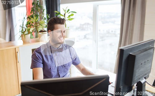 Image of happy creative male office worker with computer