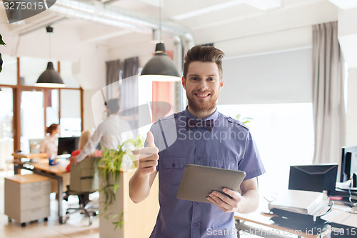 Image of happy creative male office worker with tablet pc